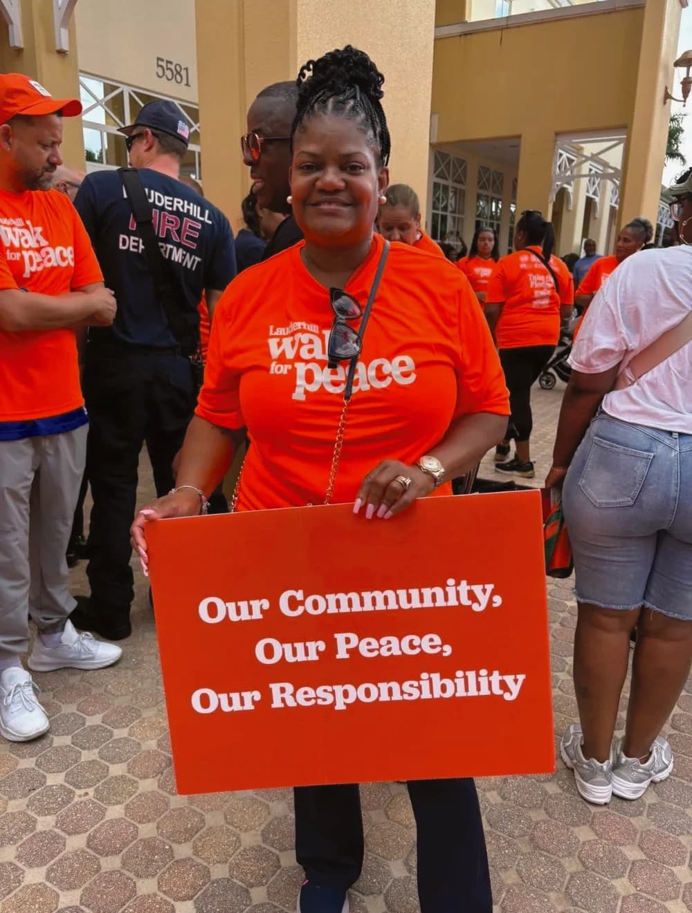 Dr. Mary Smith at Lauderhill's Walk for Peace holding a community peace sign
